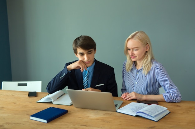 beautiful young people in the office at the table with a laptop