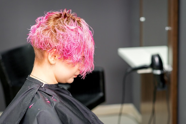 Beautiful young pink haired caucasian woman in the modern hair salon