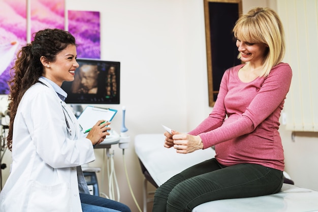 Beautiful young pregnant woman in gynecological chair during gynecological exam.