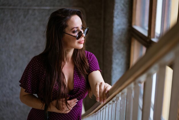 Beautiful young pregnant woman standing on stairs wearing glasses caucasian yearold pregnant woman s...