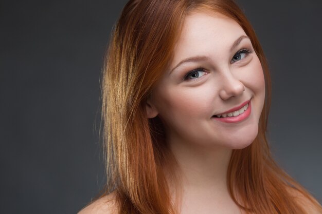 Beautiful young red-haired woman in studio