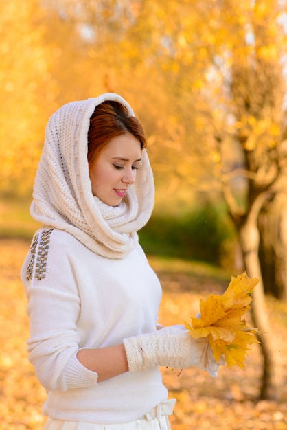 Beautiful young redhead woman in the autumn park