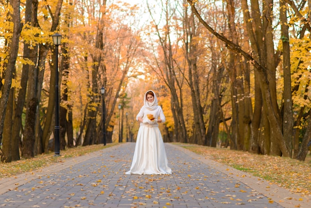 Beautiful young redhead woman in the autumn park