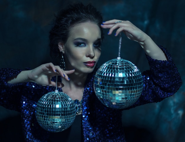 Beautiful young sensual woman holding disco ball
