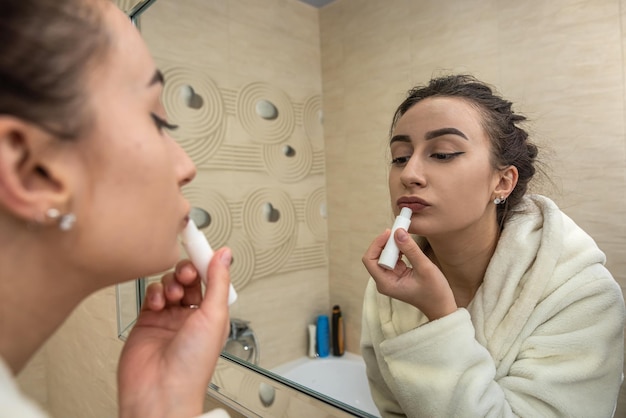 Beautiful young sexy girl corrects her makeup that was erased in a bathrobe Makeup concept