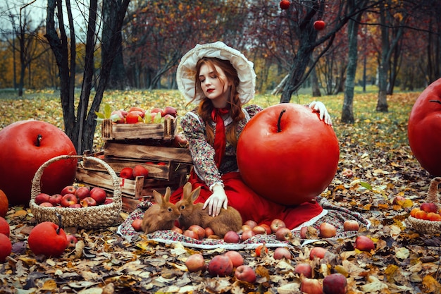 Beautiful young sexy girl with red apples  in autumn garden