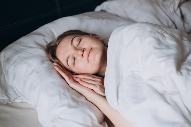 Photo beautiful young sexy woman sleeping in a white bedroom with eyes closed morning time