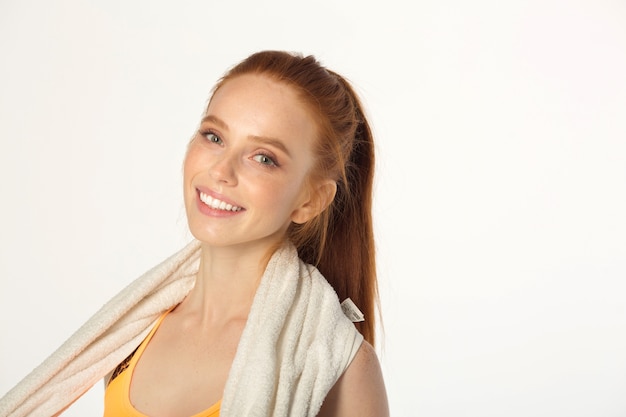 beautiful young slim woman with red hair in sportswear