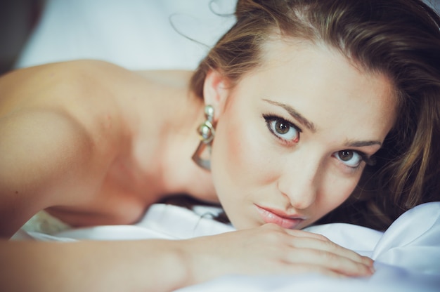 Beautiful young smiling woman in bed