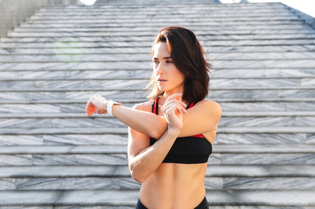Красивая молодая спортивная женщина делает упражнения на растяжку на открытом воздухе