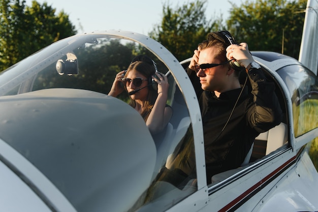 Beautiful young stylish couple in official clothes standing in private plane