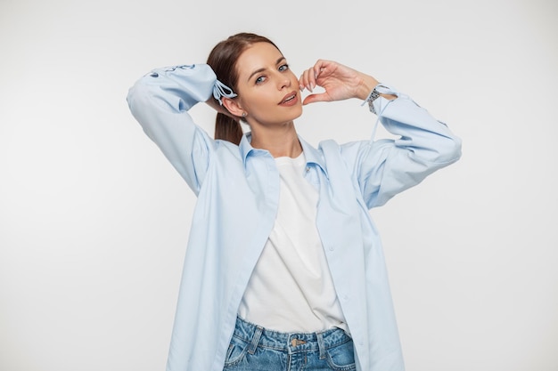 Beautiful young stylish woman with a smile in fashion casual denim clothes with a shirt and jeans on a white background