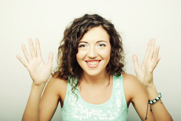 Foto bella giovane donna riccia sorpresa. studio girato.