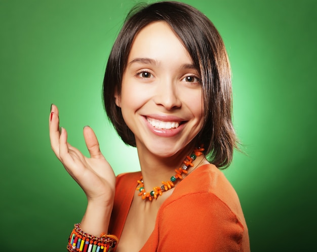 Beautiful young surprised woman over green background