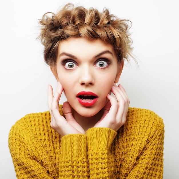 Beautiful young surprised woman. Studio shot.