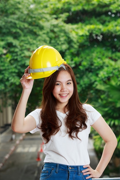 Beautiful young thai engineer with hard hat in jeans