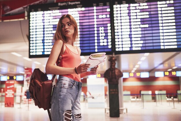 Beautiful young tourist girl with backpack in international airport