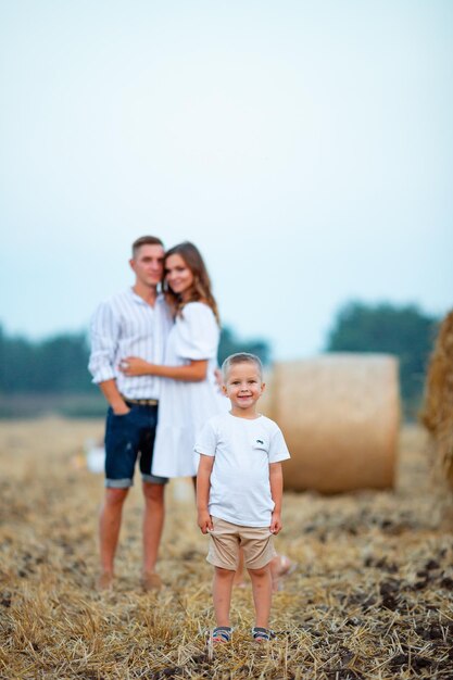 A beautiful young Ukrainian family in the field The child is in focus of the camera