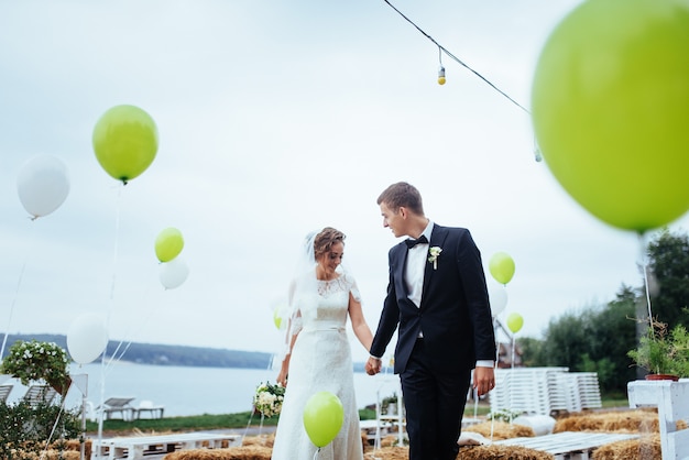 Beautiful young wedding couple kissing , blonde bride with flower