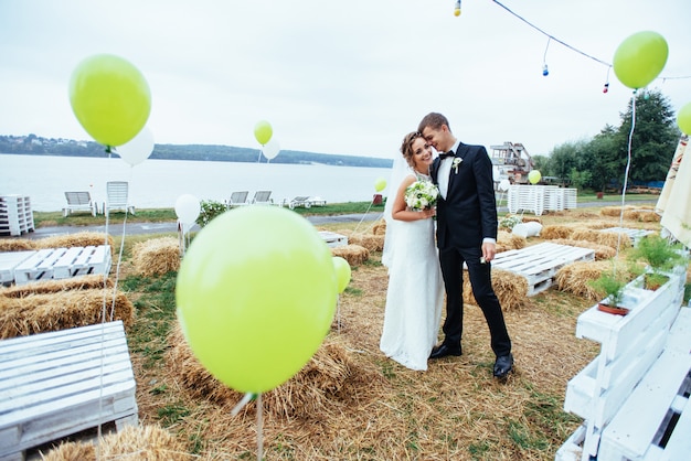 美しい若い結婚式のカップルがキス、花と金髪の花嫁