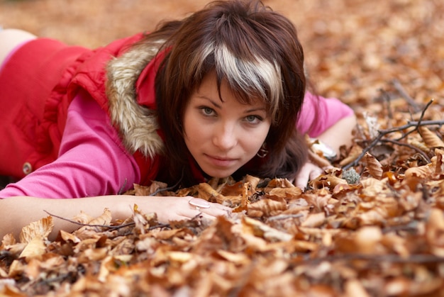 Beautiful young  with falling leaves in autumn forest