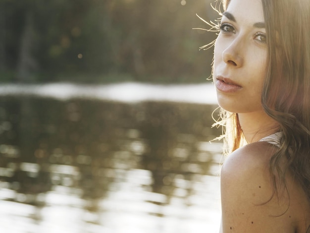 Foto una bellissima giovane donna contro il lago