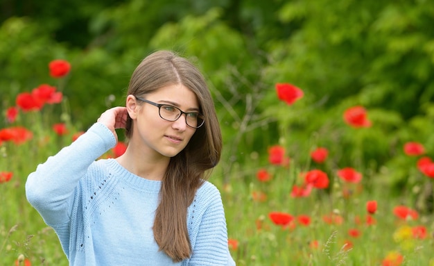 Photo beautiful young woman amidst flowers in park