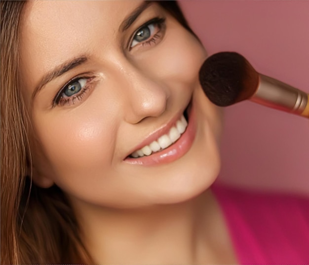 Beautiful young woman applying cosmetic powder product with makeup bamboo brush beauty makeup and skincare cosmetics model face portrait on pink background