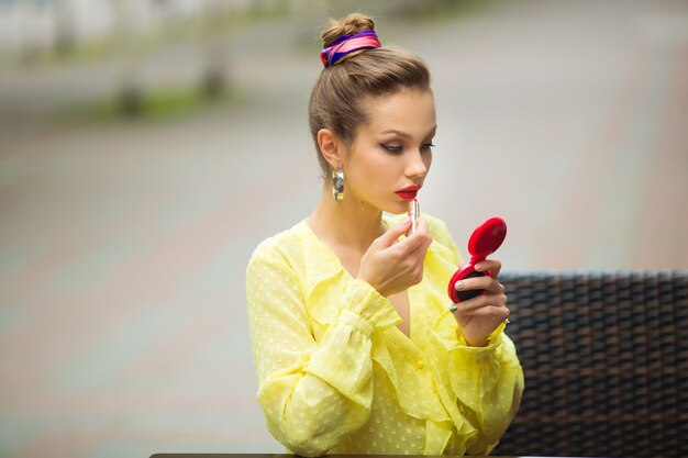 beautiful young woman applying lipstick