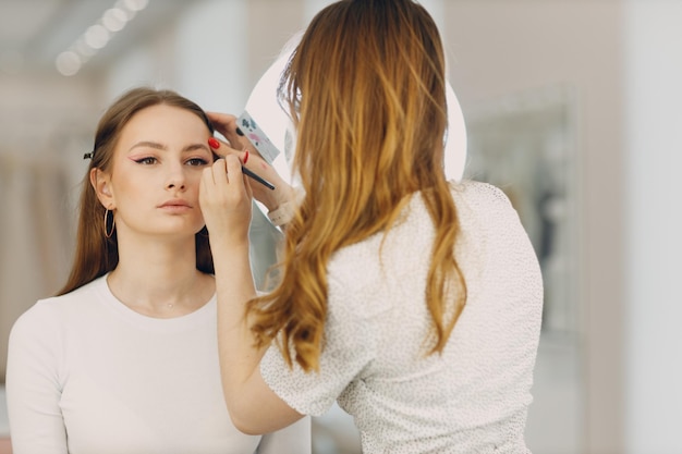 Beautiful young woman applying makeup beauty visage brush