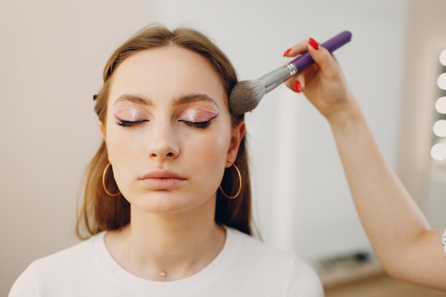 Beautiful young woman applying makeup beauty visage brush