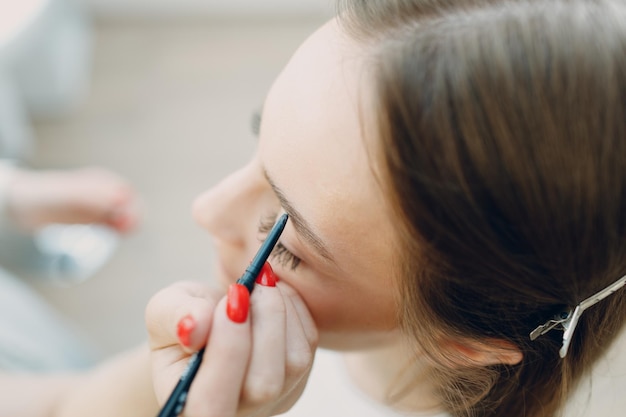 Bella giovane donna che applica la spazzola del viso di bellezza di trucco