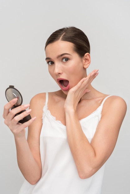 Photo beautiful young woman applying makeup