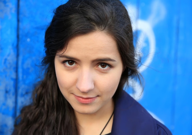 Beautiful young woman on background of blue wall