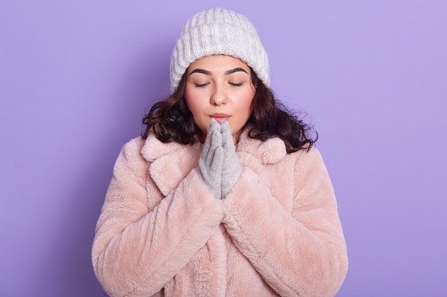 Beautiful young woman basking her hands in winter