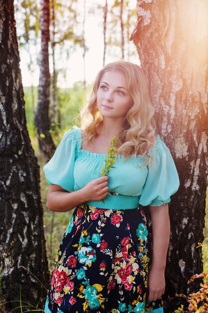 Beautiful young woman in the birch forest