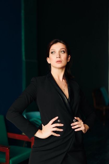 Beautiful young woman in black jacket at home