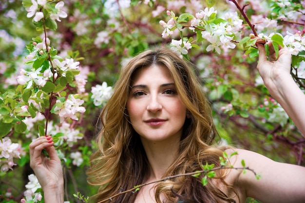 Bella giovane donna in giardino fiorito