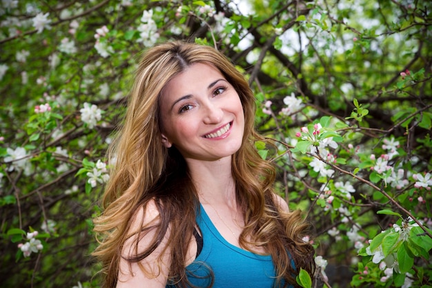 Bella giovane donna in giardino fiorito