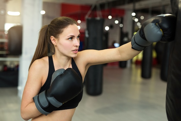 красивая молодая женщина в боксерских перчатках на тренировке