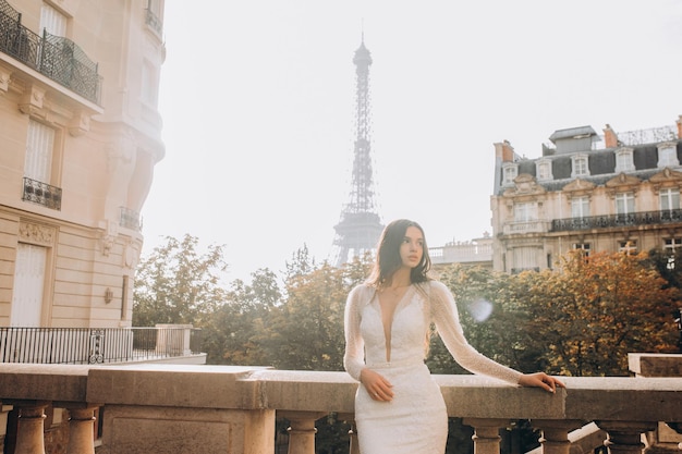 Beautiful young woman brunette bride in a wedding dress posing in front of the architecture