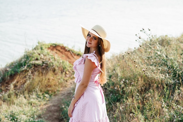 Beautiful young woman in a camomile field in a picturesque valley happy young lady and spring green nature harmony concept the idea of selfcare a healthy lifestyle and a positive attitude