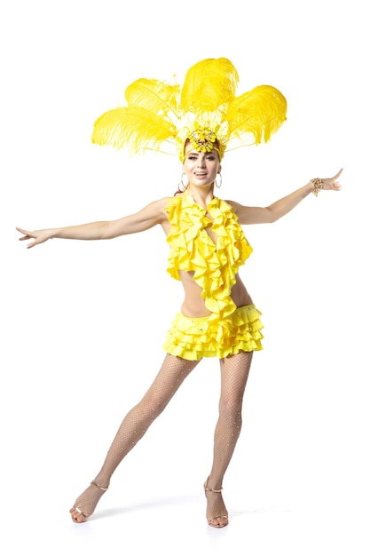 Beautiful young woman in carnival, stylish masquerade costume with feathers dancing on white studio background.