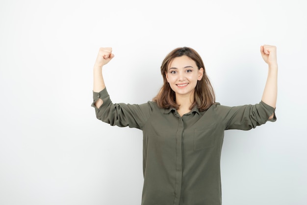 Foto bella giovane donna in abbigliamento casual che mostra i suoi muscoli.