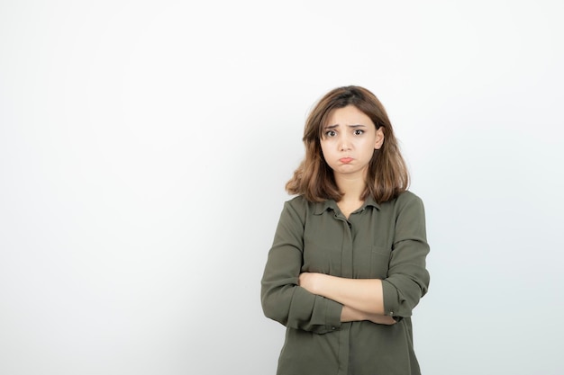 Beautiful young woman in casual outfit standing arms crossed. High quality photo