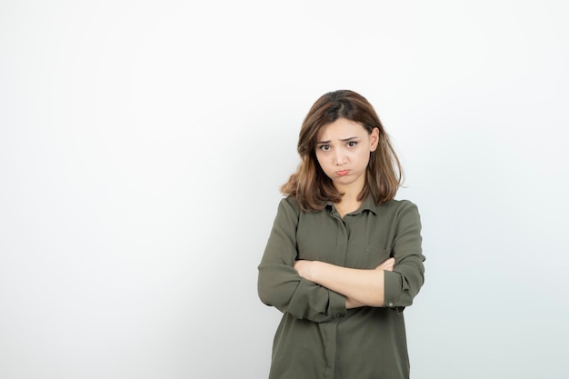 Foto bella giovane donna in abito casual in piedi con le braccia incrociate. foto di alta qualità