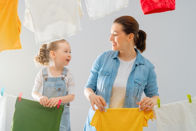 Beautiful young woman and child girl little helper are having fun and smiling