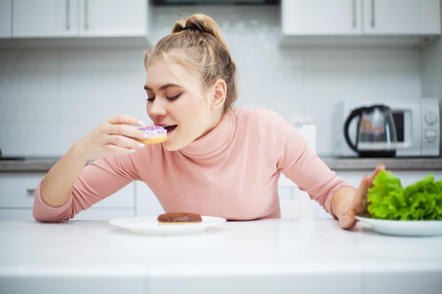 beautiful young woman choosing between healthy food and junk food