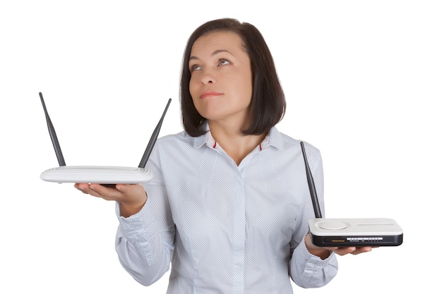 Beautiful Young Woman Choosing Between Two Wireless Modem Routers Hardware in Her Hands on a white background