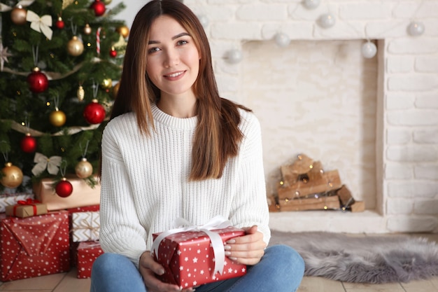 テキストのギフトの場所とクリスマスのインテリアの美しい若い女性